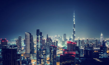 Beautiful Dubai cityscape, bird&#39;s eye view on a night urban scene, modern city panoramic landscape, United Arab Emirates (photo via Anna_Om / iStock / Getty Images Plus)