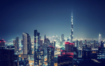 Beautiful Dubai cityscape, bird&#39;s eye view on a night urban scene, modern city panoramic landscape, United Arab Emirates (photo via Anna_Om / iStock / Getty Images Plus)