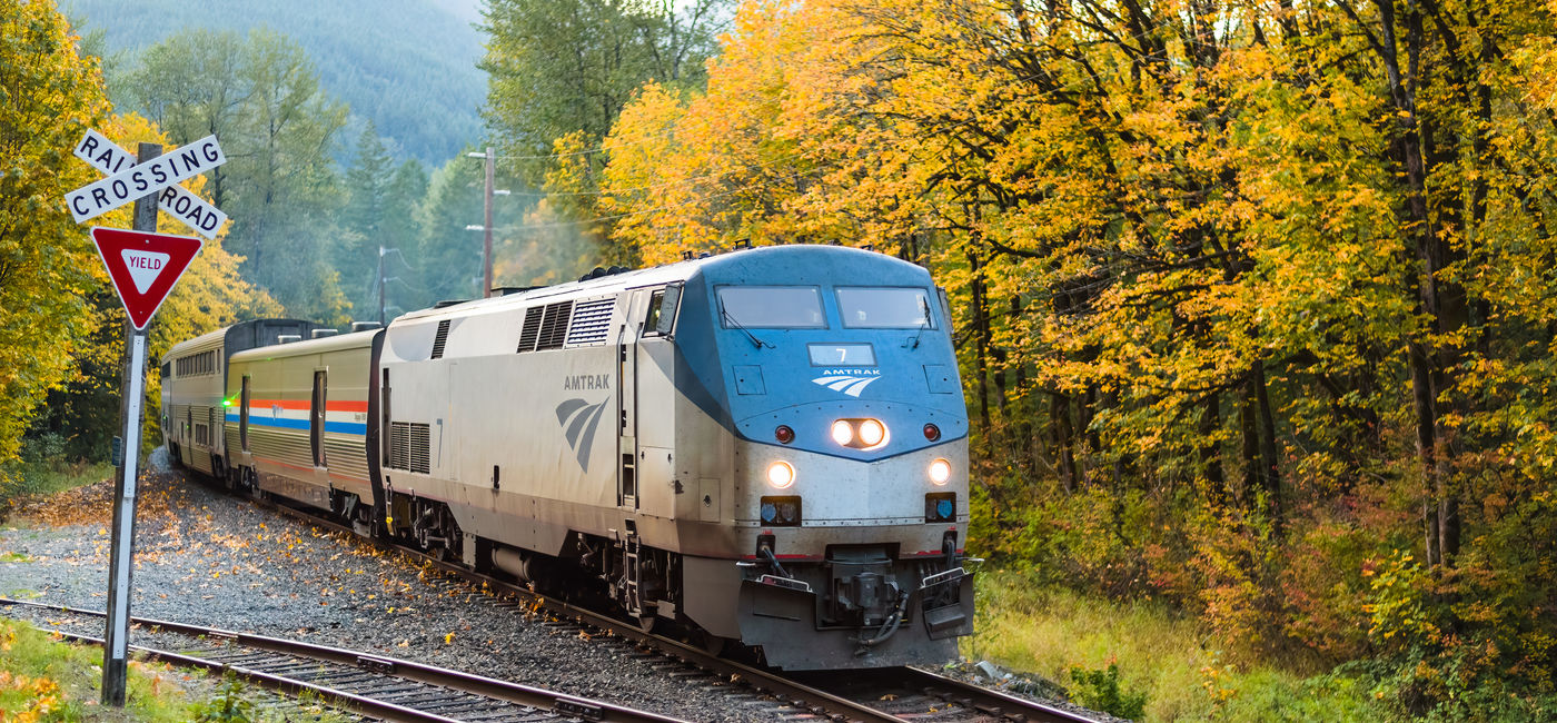 Image: An Amtrak train in autumn. (Photo Credit: Adobe Stock/IanDewarPhotography)