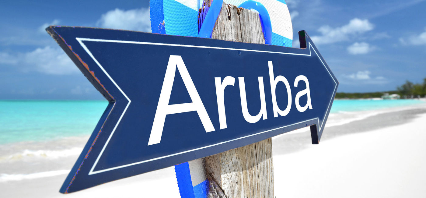 Image: Aruba sign on the beach. (photo via Pincasso / iStock / Getty Images Plus)