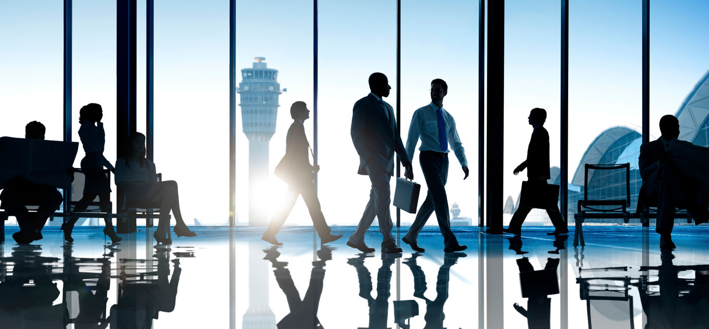 Image: Corporate or business travelers walking through the airport. (Photo Credit: Adobe Stock/Rawpixel.com)