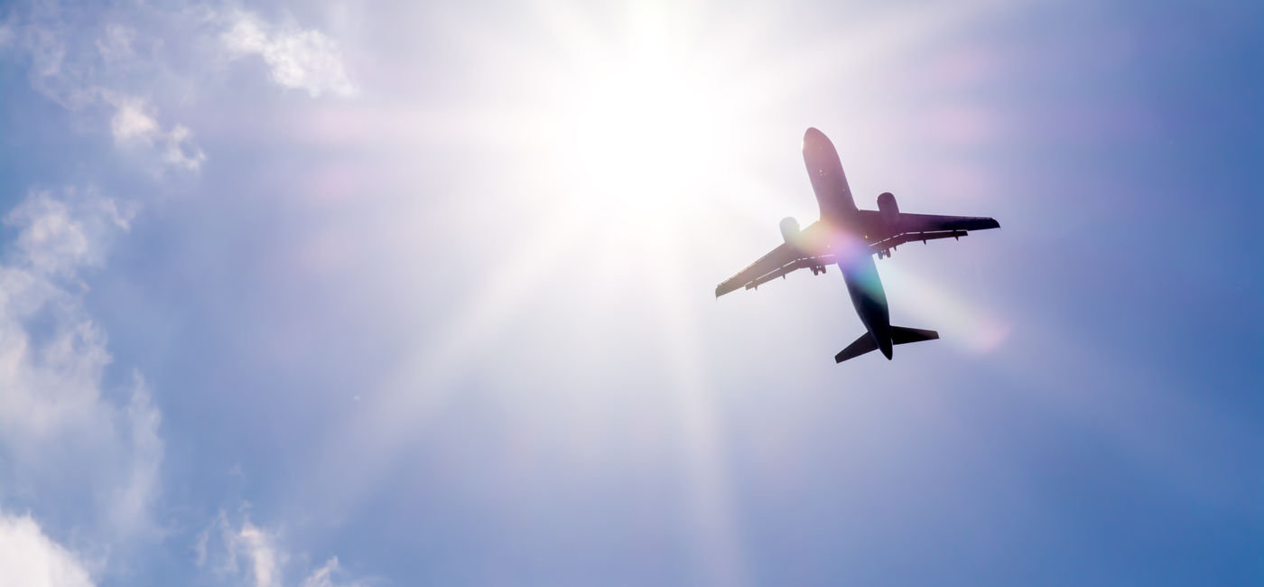 Image: Plane flying through clouds. (Photo Credit: denklim / Adobe Stock)