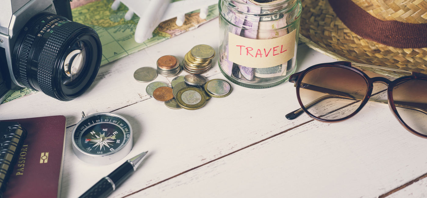 Image: Saving money for travel (Photo Credit: Kittiphan/Adobe Stock)