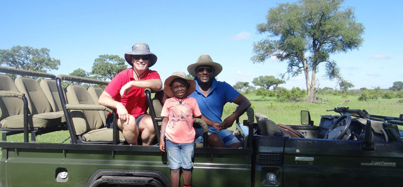 Image: Sherwin Banda, President of African Travel, Inc., and his husband and son at Sabi Sabi Private Game Reserve in South Africa. (Photo Credit: African Travel, Inc.)