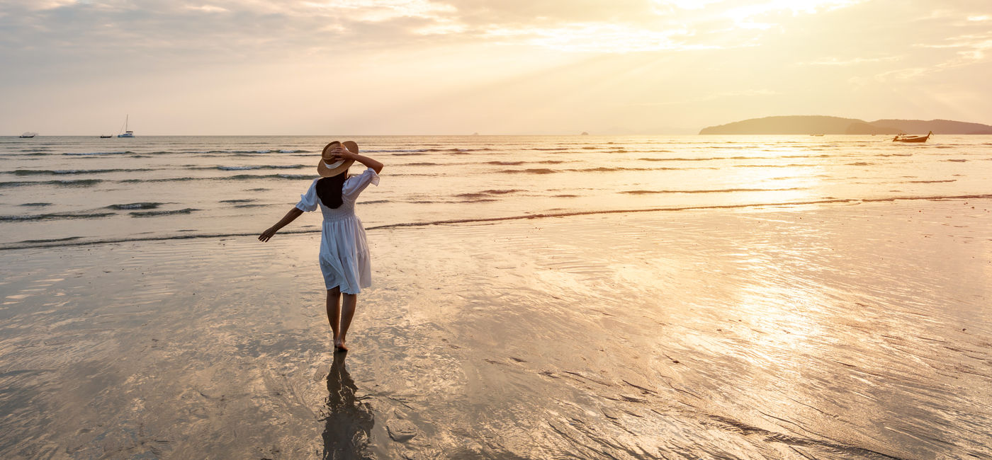 Image: Summer traveler enjoying the beach. (Photo Credit: Kittiphan/Adobe)