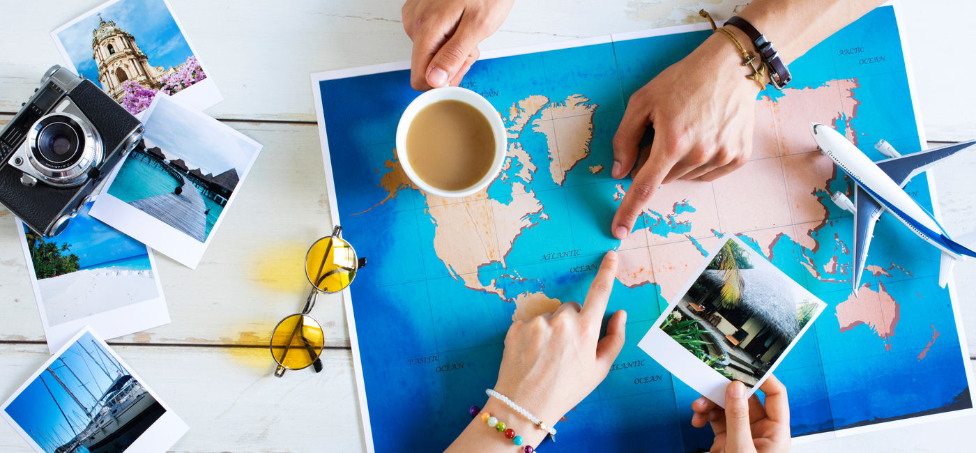 Image: Travel advisor helping plan a trip. (Photo Credit: sebra/Adobe Stock)