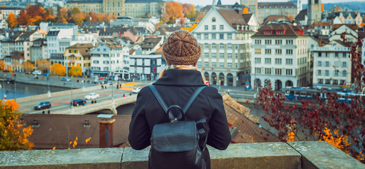 Image: Traveler backpacking through Zurich, Switzerland. (Photo Credit: Vasily Makarov/Adobe)