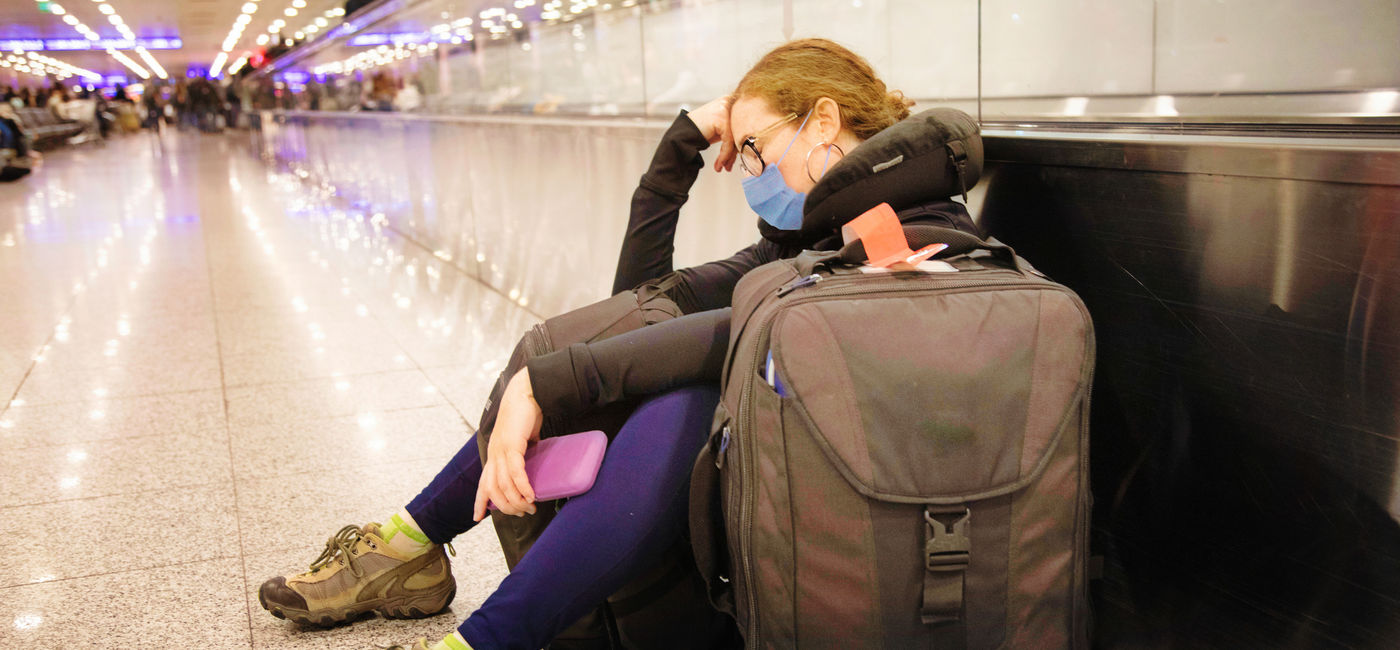 Image: Traveler waiting for delayed flight. (photo via NicolasMcComber / E+)