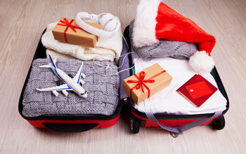 Suitcase with Christmas gifts and a Santa hat.