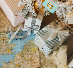 Toy airplane sitting on a map surrounded by holiday gifts.